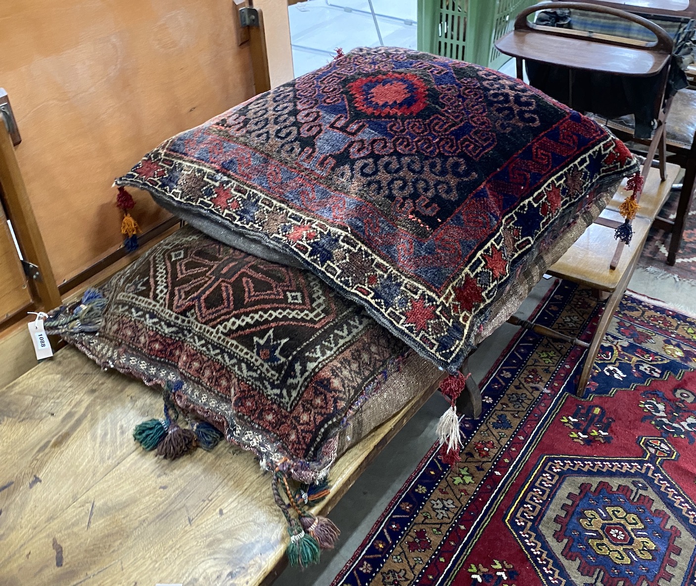 Two Afghan carpet cushions, larger 110 x 68cm